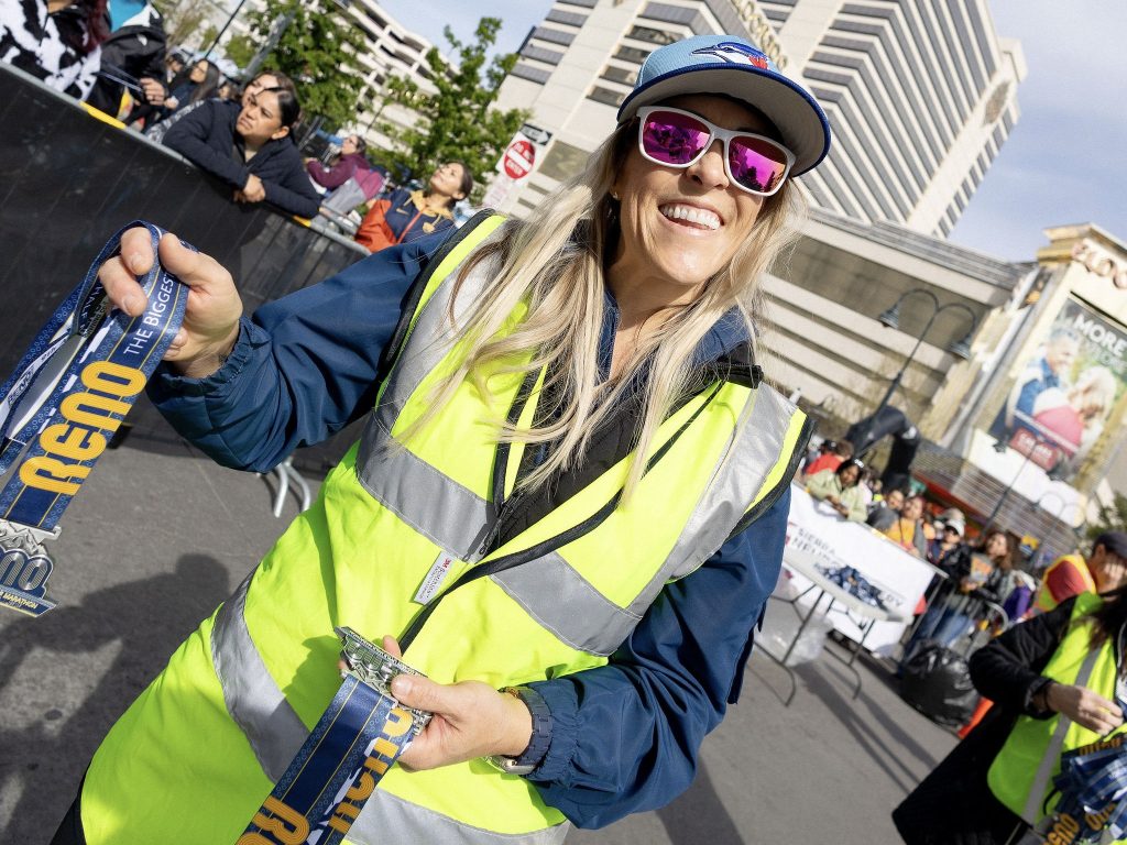 Volunteer handing out finishers medals at the Biggest Little Half Marathon in Reno